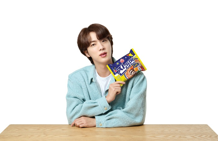 K-Pop BTS superstar Jin holding a packet of Jin Ramen